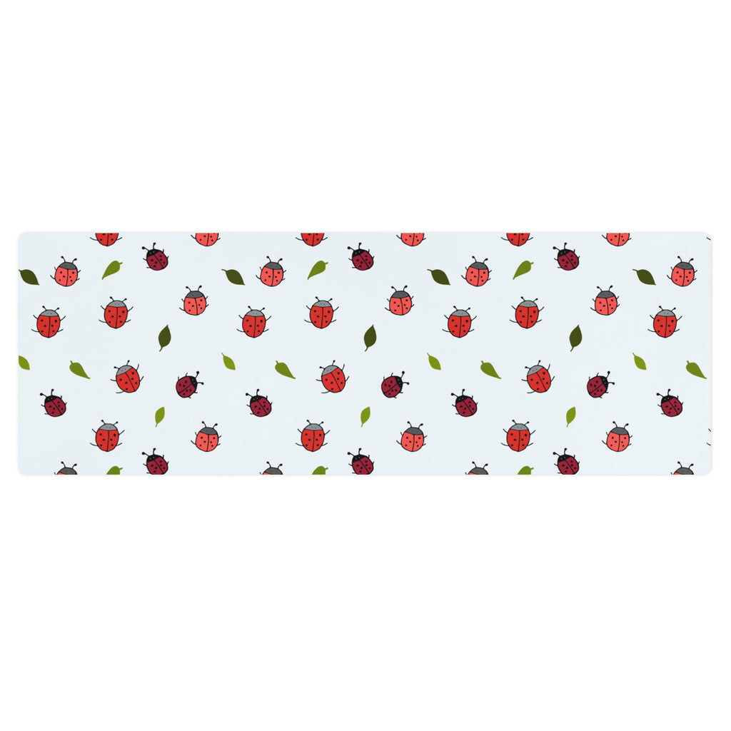 Ladybird print yoga mat on a neutral background. Red ladybirds or ladybugs with green leaves. 