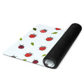 Ladybird print yoga mat on a neutral background. Red ladybirds or ladybugs with green leaves. 