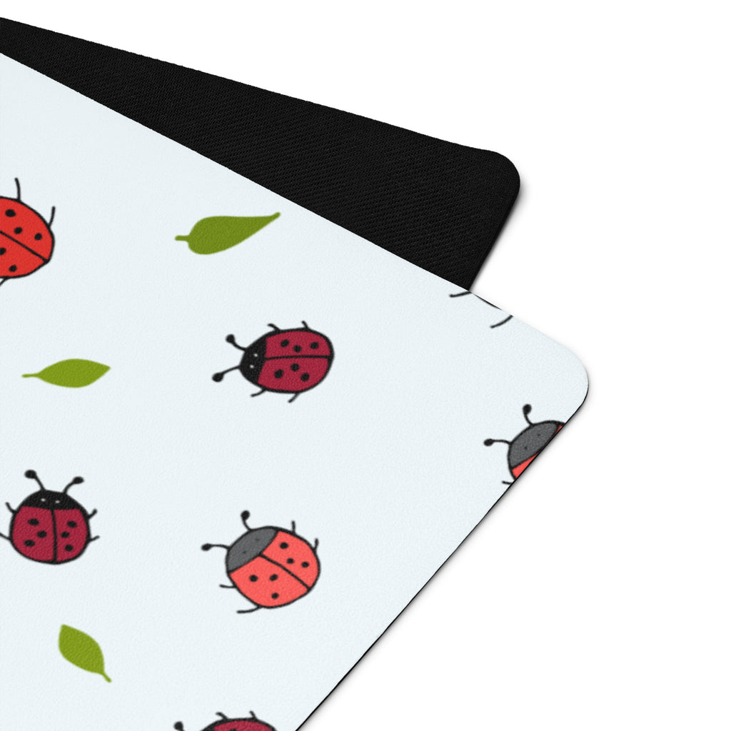 Ladybird print yoga mat on a neutral background. Red ladybirds or ladybugs with green leaves. 